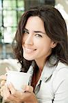 Young woman enjoying cup of coffee outdoors