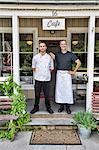 Cafe owner and chef posing in front of restaurant