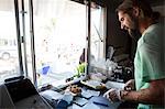 Man preparing order in fast food trailer