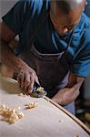 Craftsman making paddleboard in workshop