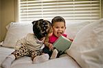 Toddler gives her baby sister a kiss on the cheek.