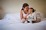 Happy young mother playfully tickling her toddler daughter.