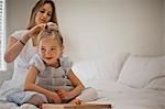 Woman styling her daughter's hair.