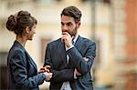 Young businessman focusing intently on his female colleague.