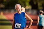 Portrait of a smiling senior man standing on a sports track.