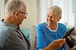 Happy senior couple looking at an old framed photograph.