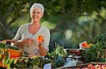 Mature woman shopping for fresh vegetables at a farmer's market.