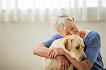 Portrait of a happy mature woman hugging her pet Labrador.