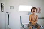 Happy young boy laughing while at the doctor's for a check up.