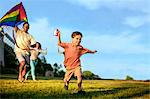 Little boy flying a kite with his parents.