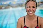 Portrait of a smiling middle aged woman by a the swimming pool.