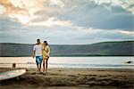 Middle aged couple walking together on the beach.