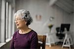 Portrait of a senior woman gazing pensively out a window.