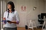 Portrait of a young female doctor holding a clipboard in her office.