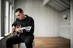 Teenage boy playing his electric guitar.