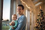 Portrait of a smiling father holding his baby daughter.