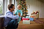 Father holding his baby daughter at Christmas.