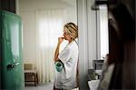 Woman drinking coffee in kitchen.