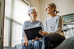 Senior woman and adult daughter share memories.