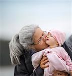 Grandmother holding her baby granddaughter on the beach.