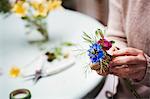 A florist creating a small posy or buttonhole.