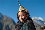 A Layap girl wearing a traditional hat smiles for the camera in the remote village of Laya, Bhutan, Asia