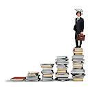 Scale with books and man with graduation hat