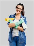 Pretty woman wearing gloves and holding a cleaning spray and a cloth