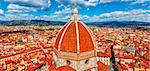 Panoramic view to dome of cathedral Santa Maria del Fiore in Florence and red tegular roofs of old town, clouds on the sky