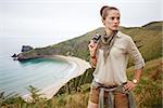 Into the wild in Spain. healthy woman hiker with camera in front of ocean view landscape