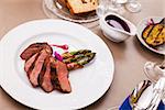 Grilled duck breast with bacon asparagus and raspberry sauce