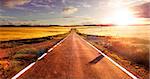 Adventures and road trips.Sunset and travel concept.Road and fields