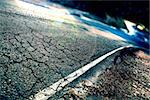 Travel concept. Cracked asphalt and curve road.Road lines