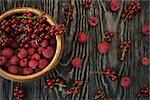 Fresh berries raspberry and red currant in bowl on wooden table