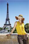 young woman in bright blouse in the front of Eiffel tower