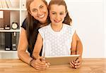 Mother and daughter at home using a tablet