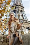 Autumn getaways in Paris. Portrait of happy young tourist woman on embankment near Eiffel tower in Paris, France with selfie stick