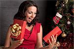 Woman opening a gift box.Christmas season.Xmas tree