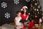 Smiling and happy family with tablet pc. Christmas decoration