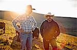 Two farmers standing on a paddock.