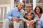 Portrait of a happy family sitting on their front porch.