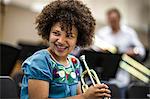 Teenage girl learning to play trumpet.