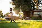 Young boy having fun pretending to be a pilot in a cardboard plane.