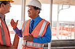 Two construction managers talking on building site.