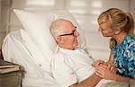 Young nurse holding the hands of an elderly patient.