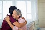 Smiling young nurse comforting an elderly woman.