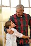 Smiling young girl hugging her grandfather.