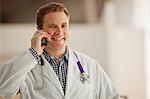 Portrait of a smiling male doctor talking on a mobile phone.