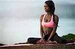 Young woman practicing yoga on a beach.