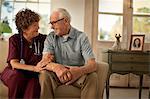 Smiling mature nurse comforting an elderly patient.